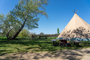 Indian tent in a green environment and under a blue sky.