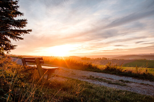 Bank am Wegesrand bei Sonnenuntergang