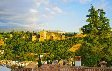 Sunset over Granada, Spain. City landscape with Alhambra palace and Sierra Nevada mountains on horizon.