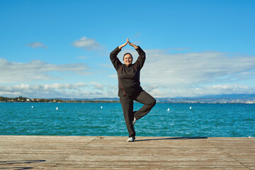 Active senior woman doing healthy exercises outdoors