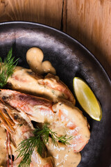 Delicious fried langoustines in sauce on a black plate, prepared in an Asian style. Fast and ready meal concept