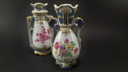 Close-up on two Chinese vases with a floral pattern on a dark background