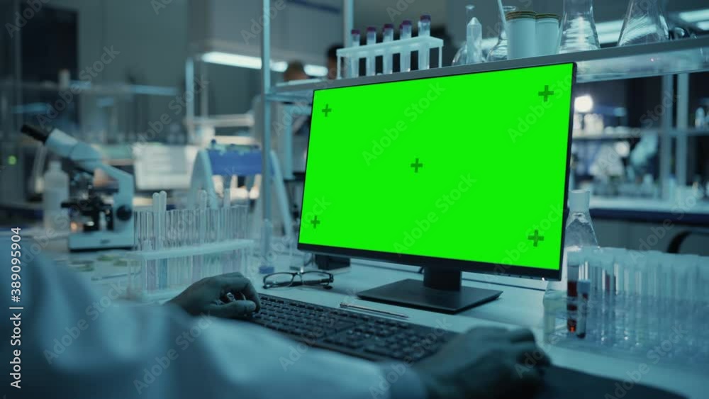 Wall mural medical research scientist working on desktop computer with green screen mock up template in applied