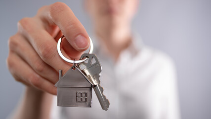 Close-up view of realtor giving home key. Mortgage. Concept of buying new house.
