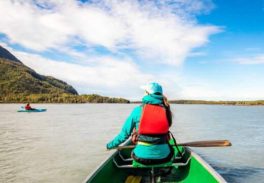 Young Woman Kayaking In The Sea At Sunny Day From The Back