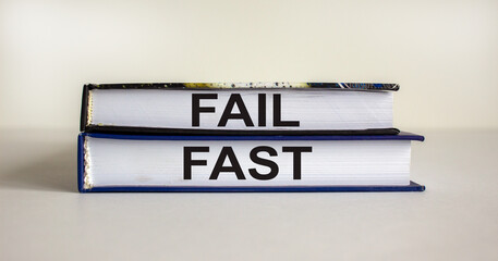 Books with text 'fail fast' on beautiful wooden table. White background. Business and fail fast concept. Copy space.