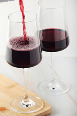 Red wine pouring to a white glass