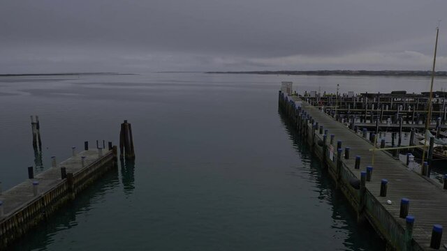 Ferry Leaving Nantucket Island Harbor on gray cloudy day with heavy stormy clouds, deck view