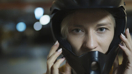 Naklejka na ściany i meble Portrait of young blonde woman with safety helmet in underground parking garage. High quality photo