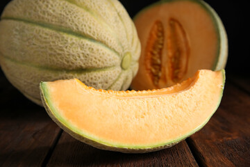 Slice of tasty fresh melon on wooden table, closeup