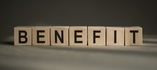 Wooden blocks with lettering "benefit" on gray background.