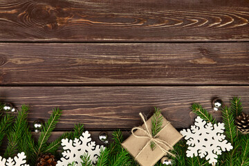 Winter holidays background with fir tree branches, gift box and snowflakes