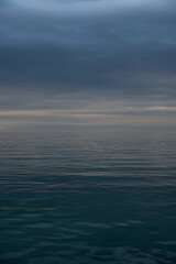 blue sky and sea on a cloudy day during sunset with calm waters