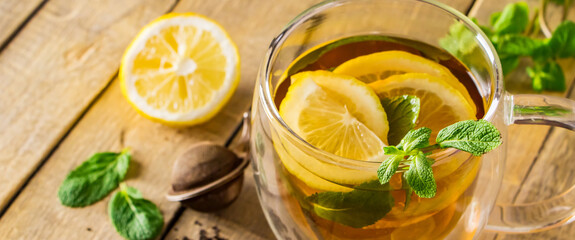Tea with lemon and mint in transparent cup. Alternative medicine. Hot drink for relaxation.