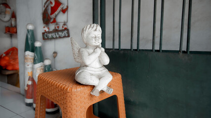 Christmas wooden white colorize toy of angel sits on a chair
