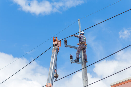 Electricians Wiring Cable repair services,worker in crane truck bucket fixes high voltage power transmission line,setting up the power line wire on electric power pole.