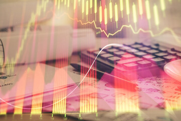 Double exposure of financial chart drawings and desk with open notebook background. Concept of forex market