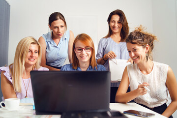 Group of women female only colleagues working together on project sitting by the desk using laptop at work in the office - Millennial boss and entrepreneurs having meeting brainstorming concept