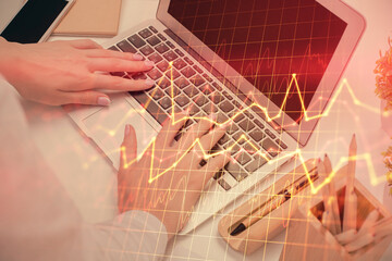 Multi exposure of woman hands typing on computer and forex chart hologram drawing. Stock market analysis concept.