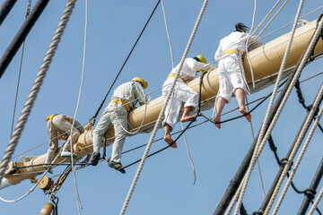 帆船のヤード上で帆走の用意をする乗組員 © captainT