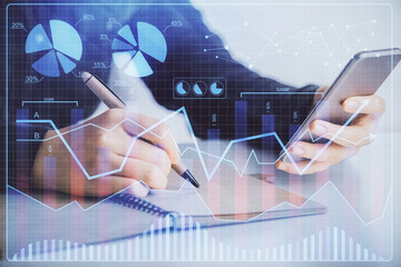 Double exposure of forex graph sketch hologram and woman holding and using a mobile device. Stock market concept.