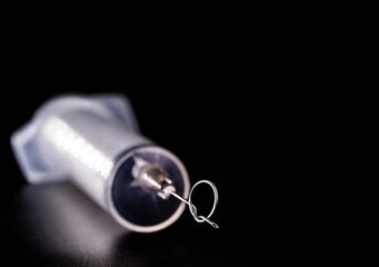 syringe or injection with a knot in the needle, conceptual image about the growth of the anti-vaccine movement