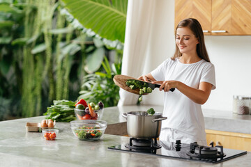 Fototapeta premium Young woman cooking in the kitchen.