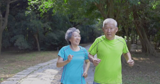 Asian Senior Couple  jogging in the nature park