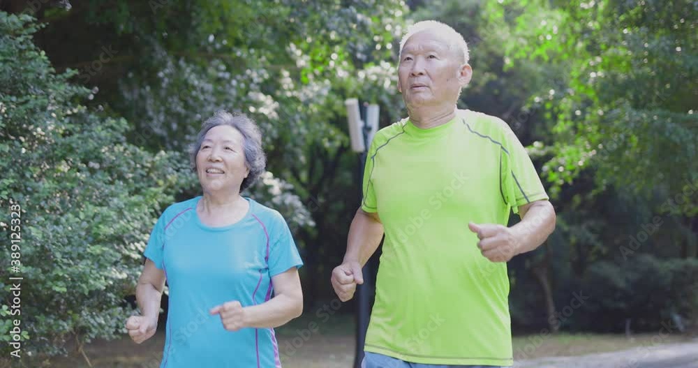 Wall mural asian senior couple jogging in the nature park