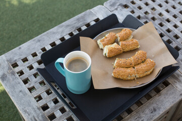 Bread and coffee on the black tray.