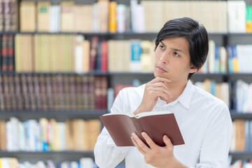 図書館で考え事をする男性