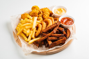 The beer plate with spicy chicken wings, calamari rings, fries onion rings, cheese balls, breaded, ketchup and mustard sauce