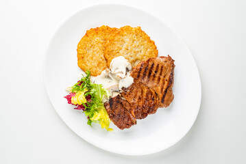 pork steak with potato pancakes and salad
