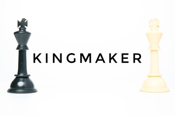 A picture of kingmaker word with black and white chess king on white background. Kingmaker concept.