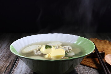 Hot clear soup of egg tofu, minced pork meat and sliced Chinese fish sausage seasoning with pepper and coriander in the bowl. Famous traditional soft and light menu for easy digestion. 