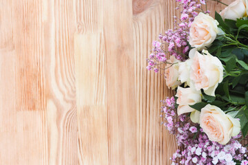 beautiful delicate bouquet of gypsophila and roses on a wooden textured background. copy space.