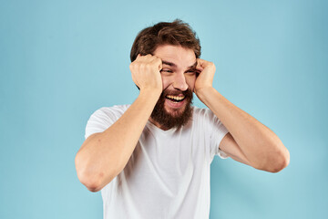 Fototapeta premium Emotional man with a beard in a white t-shirt blue background fun lifestyle