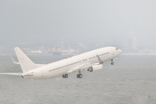 white airplane taking off in haze afternoon with ocean background