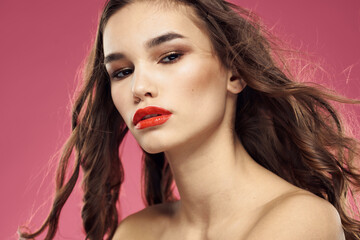 Beautiful woman with red lips on a pink background nude shoulders cropped view