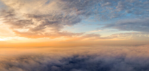 Orange dawn over the clouds. Aerial view. the other side of the sky.