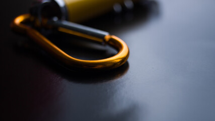 Bottom of a laser pointer with multiple modes on a dark background. Metal carbine on the laser. Point to something. Children's toy. Small yellow metal flashlight. Place for text.