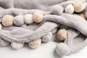 Fototapeta na wymiar Grey blanket with pompoms. Pleated fabric, background.