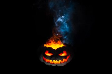 Naklejka premium A terrible pumpkin with burning eyes, a cloud of smoke enveloped it. Halloween is coming soon