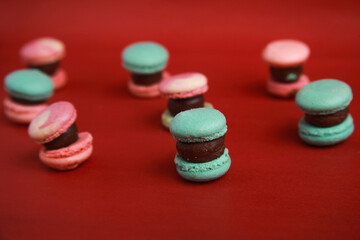 mini korean macarons on red colored background. Minimal food photography concept with copy space for text.