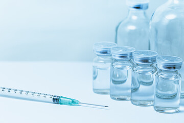 Vaccine bottle with syringe injection medical needle with space for text blue color tone.