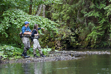 Young woman learning to fly fishing with a profesional guide