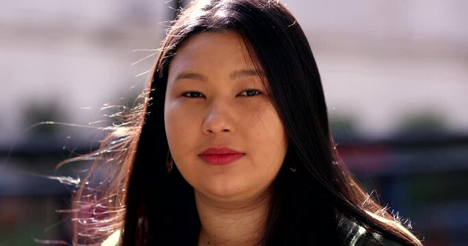 Larger young Asian woman portrait face looking at camera