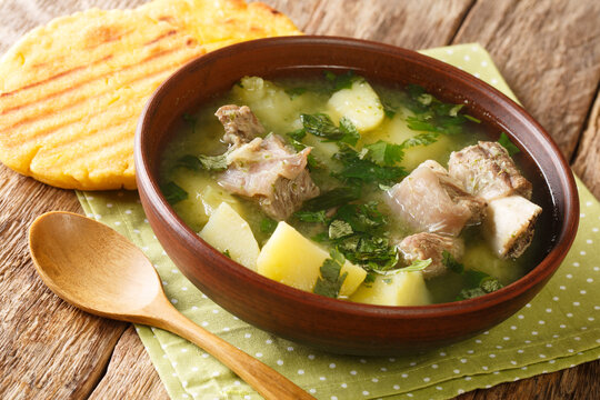 Delicious traditional soup of beef ribs with potatoes and herbs Caldo de costilla close-up in a bowl on the table. horizontal