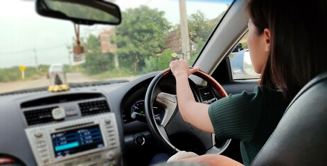  Young woman driving  a car on travel afternoon.