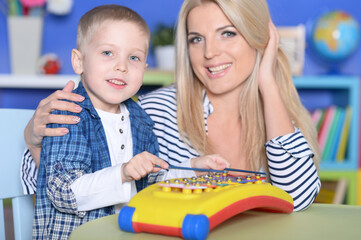 Young mother and cute little son playing